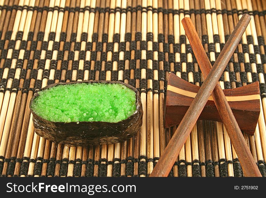 Green colored sushi on a placemat with chopsticks