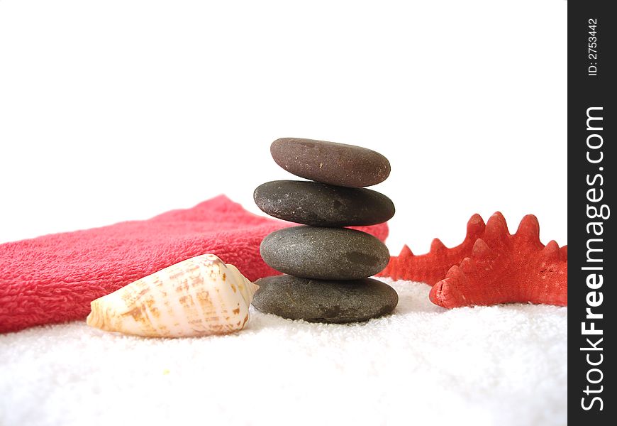 Spa essentials (pyramid of stones with white towel and seashell)