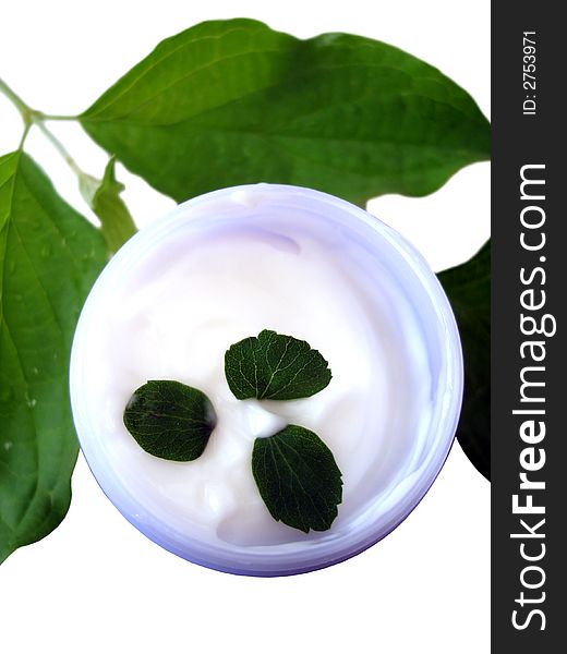 Container of cosmetic cream with leaves