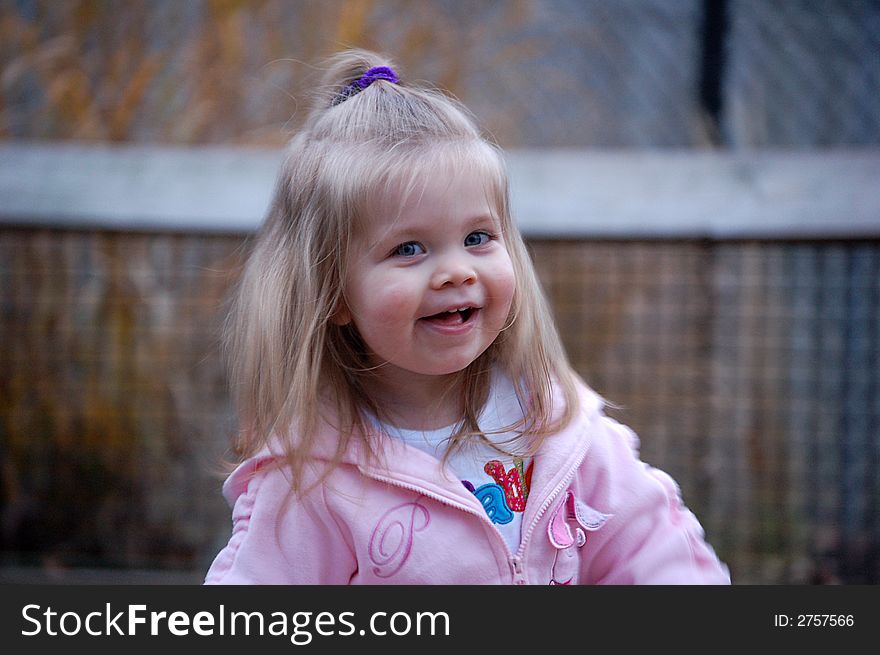 Two year old girl in pink smiling or laughing. Two year old girl in pink smiling or laughing.