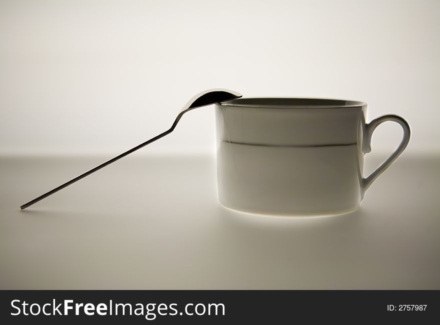 Isolated - white coffee mug with the spoon outside of it. Isolated - white coffee mug with the spoon outside of it