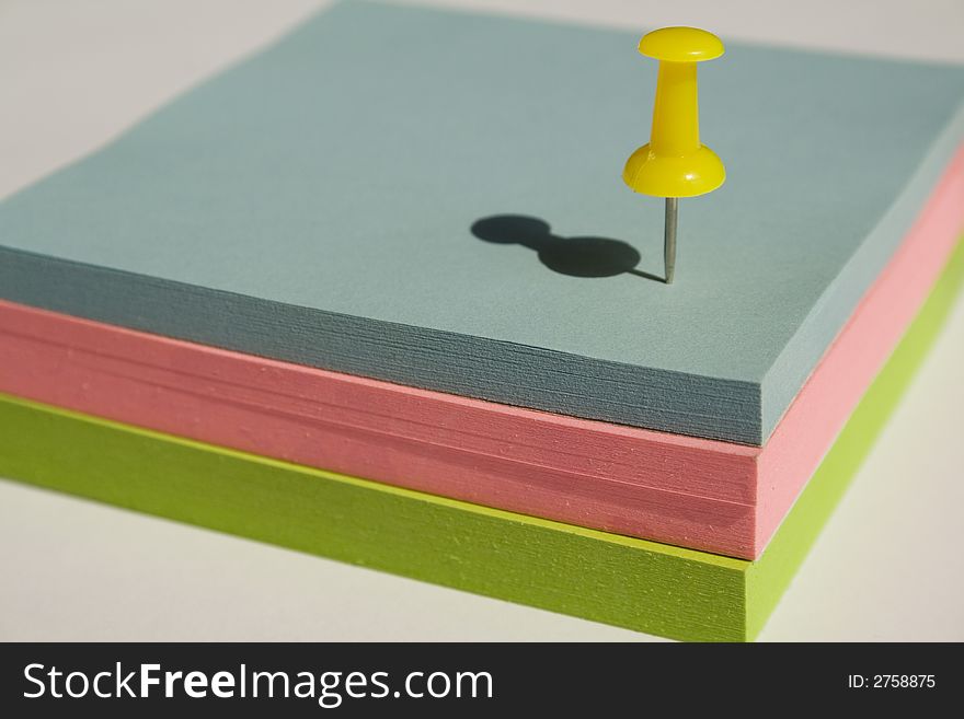 Pad of sticky notes with a yellow pin