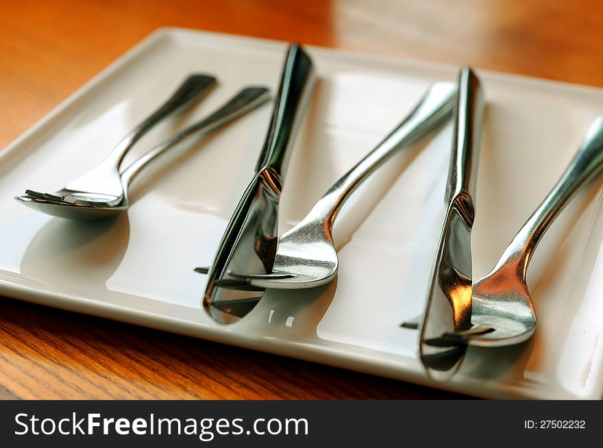 Metall fork and spoon on the plate. Metall fork and spoon on the plate