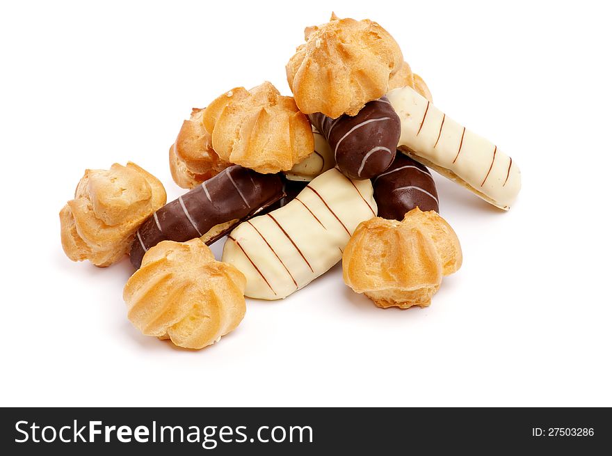 Heap of Profiterole and Eclair with Dark and White Chocolate Glaze closeup on white background. Heap of Profiterole and Eclair with Dark and White Chocolate Glaze closeup on white background