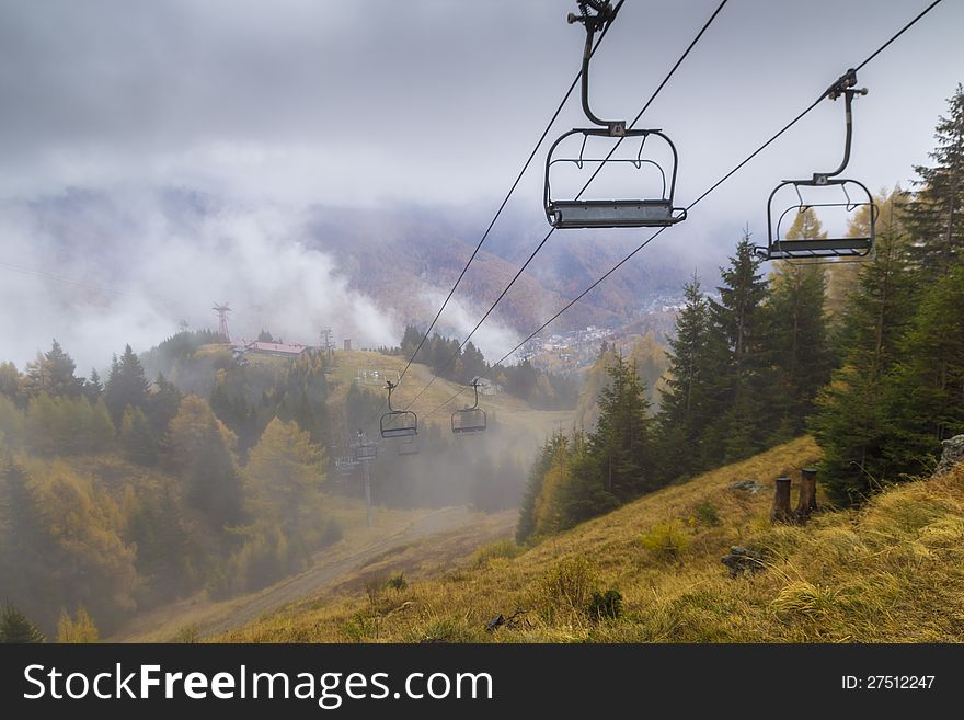 Chair lift in foggy mountain