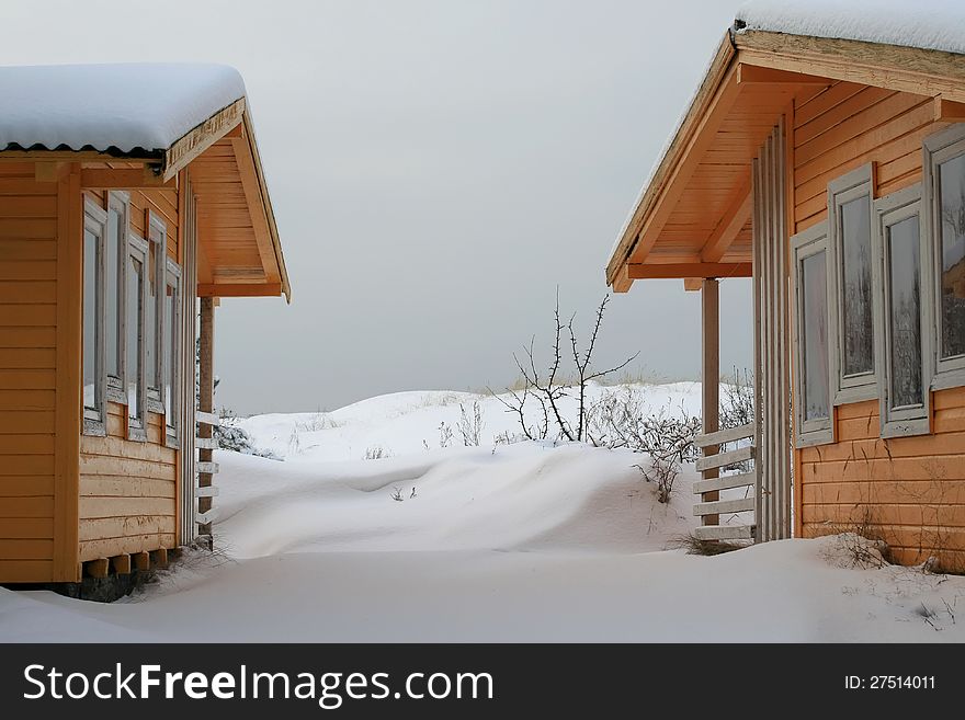 Two little wooden cottages in winter