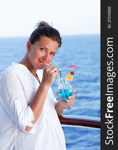 Cute brunette girl enjoys traveling on a ship at sea