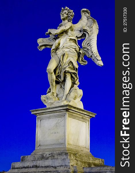 One of Bernini`s statue of angels (Angel with the superscription) on Ponte Sant`Angelo, in front of Castel Sant`Angelo in Rome