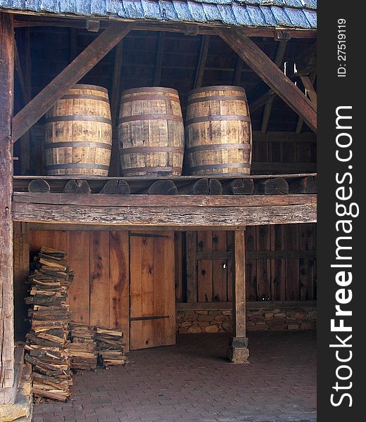 Old-fashioned barrels in a shed above firewood