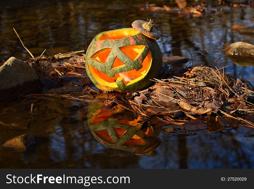 Pumpkin head on the water with the reflection. Pumpkin head on the water with the reflection