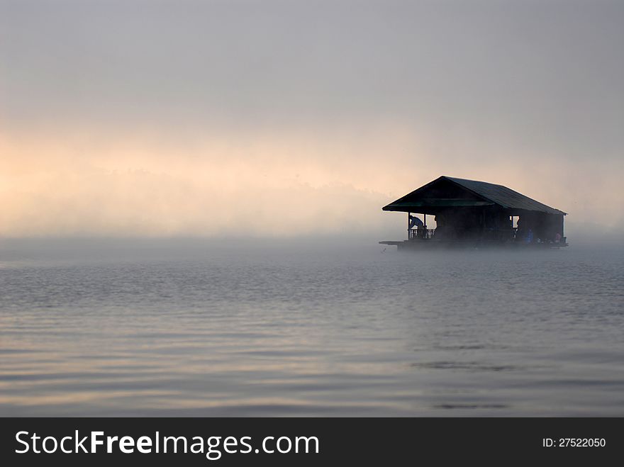 Floating home in the morning fog.It's a floating house for tourists.Samprasobriver Sangkhlaburi thailand.