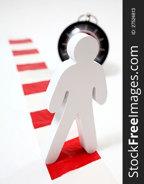 Wooden figute standing on chevron in front of a clock. Wooden figute standing on chevron in front of a clock.