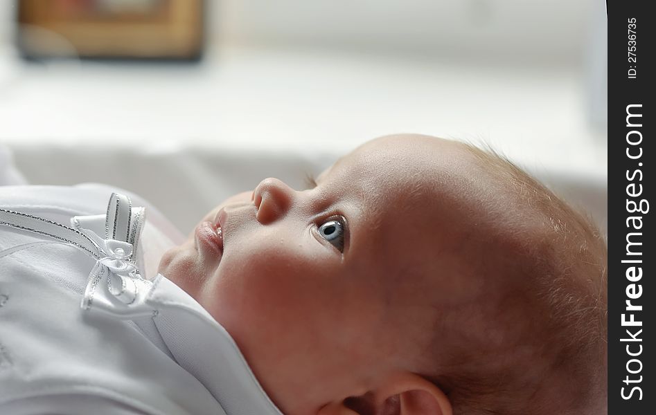 On a white background cute baby lying in a beautiful dress. On a white background cute baby lying in a beautiful dress