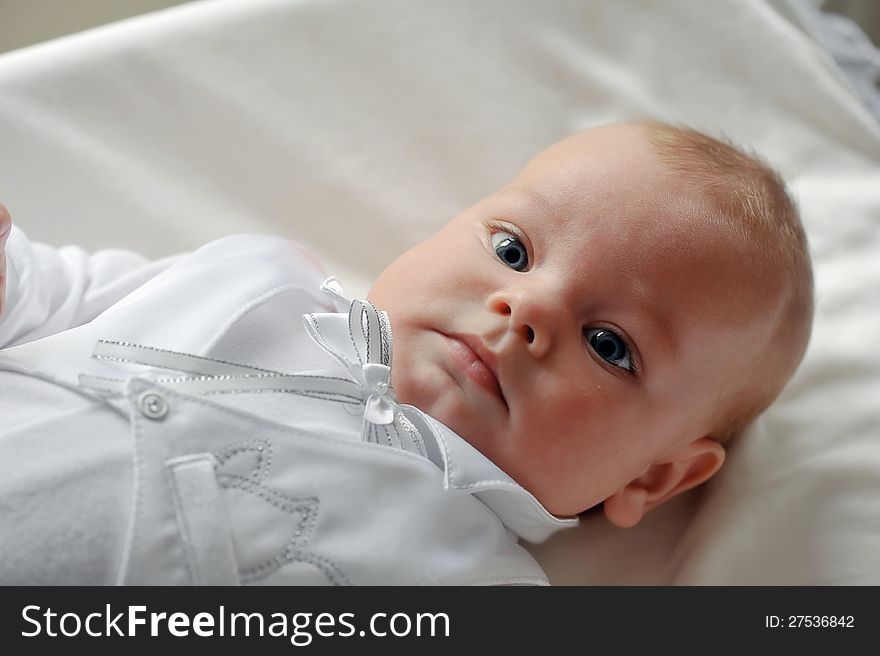 On a white background cute baby lying in a beautiful dress. On a white background cute baby lying in a beautiful dress
