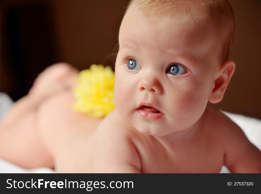Lays bare a beautiful baby with yellow flower on her back