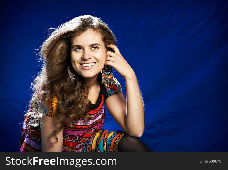 Beautiful young woman with long hair on a blue background