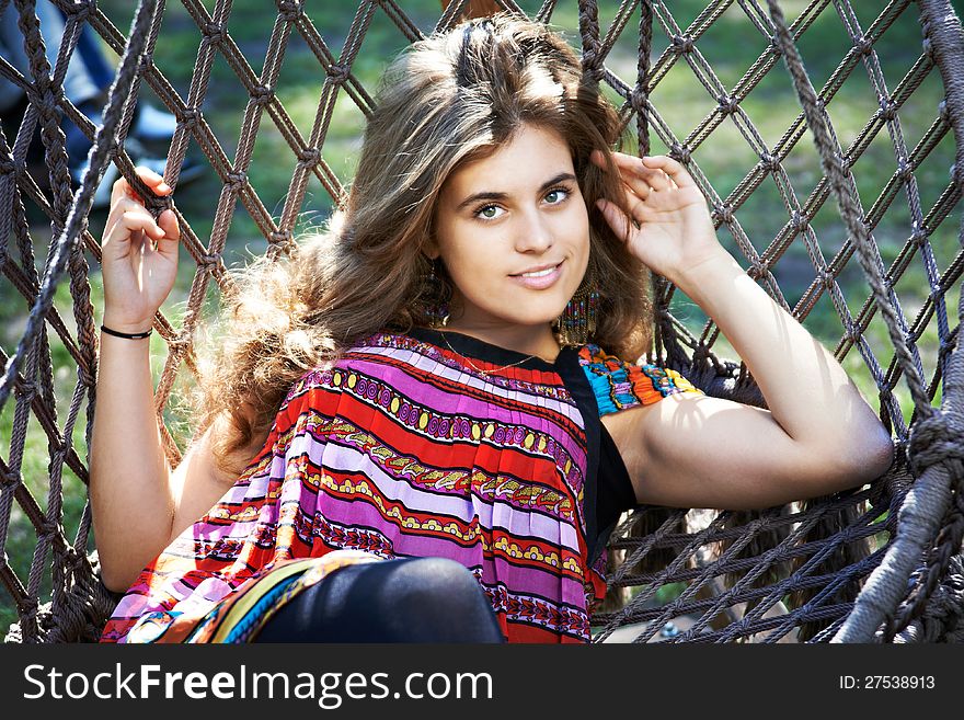 Beautiful young woman with long hair in a hammock in park. Beautiful young woman with long hair in a hammock in park