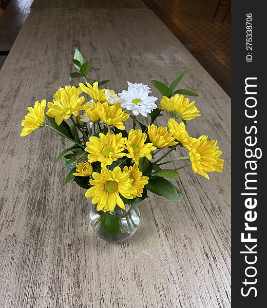 beautiful yellow flower in a transparent pot on the table