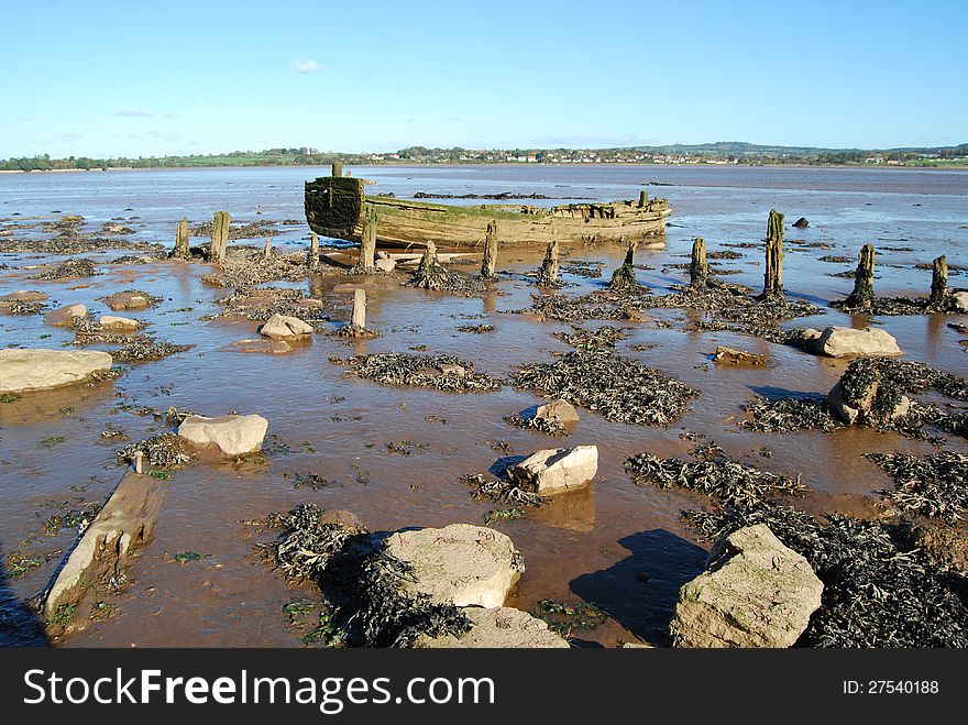 Old rotting rowing boat at low tide at Exmouth Bay. Old rotting rowing boat at low tide at Exmouth Bay