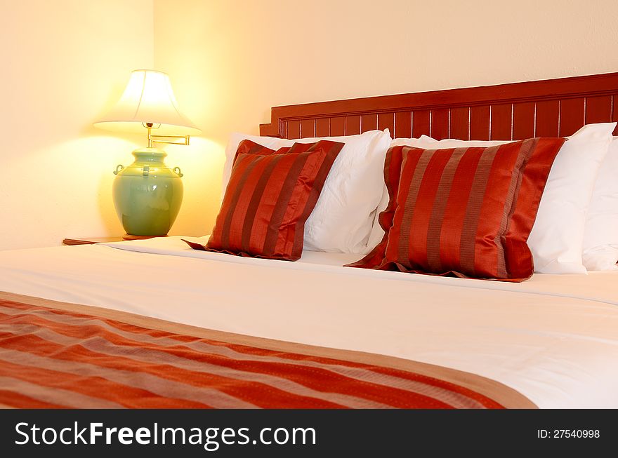 The bedroom decorated decorated in red and white with warm light . The bedroom decorated decorated in red and white with warm light .