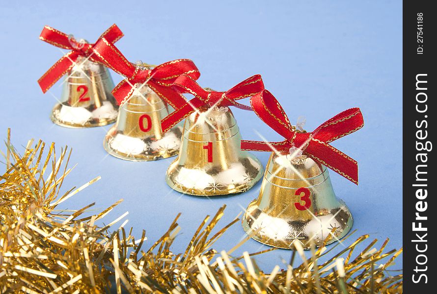 Christmas golden bells with red ribbon on blue background. Christmas golden bells with red ribbon on blue background