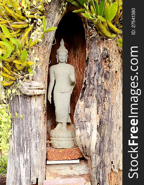 An ancient Buddha statue placed in wood cave. An ancient Buddha statue placed in wood cave.