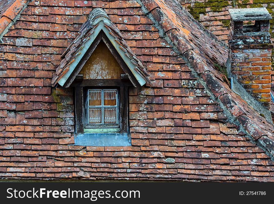 Old brick roof with window and a chimney