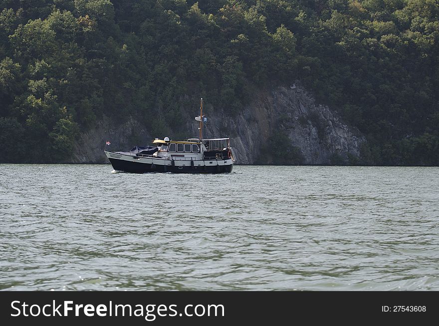 A solitary boat cruising the Danube river at Cazane gorge. A solitary boat cruising the Danube river at Cazane gorge