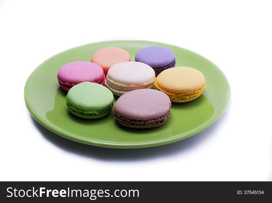 Colored sweets on green dishware isolated on white background. Colored sweets on green dishware isolated on white background