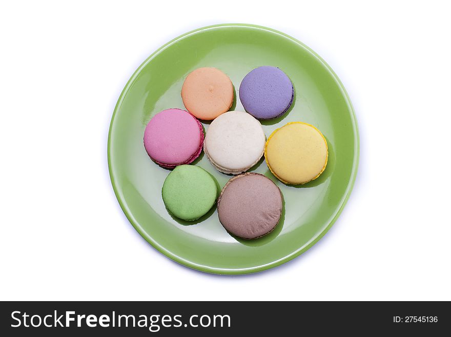 Colored sweets on green dishware isolated on white background. Colored sweets on green dishware isolated on white background