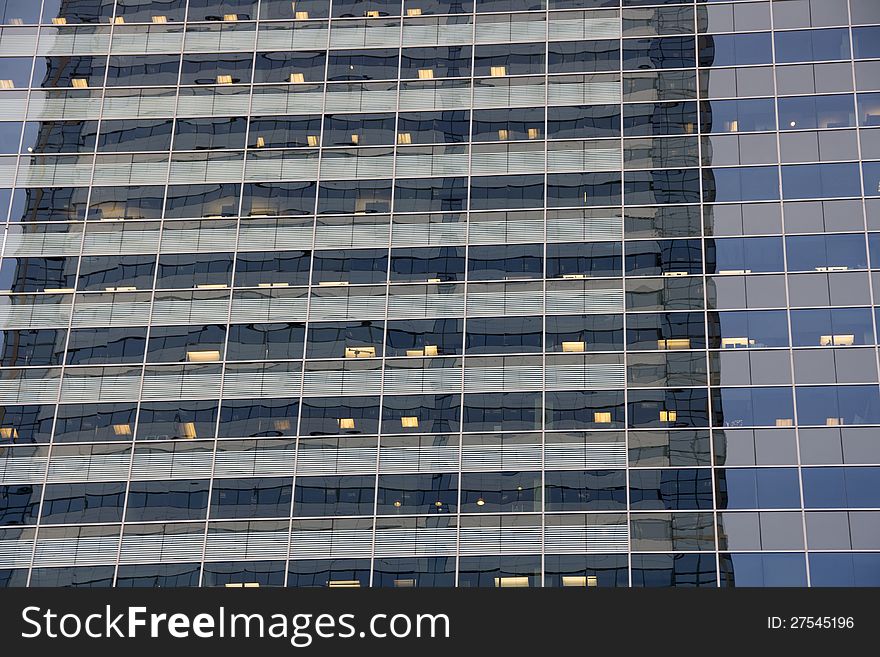 An office building with clear windows and lights. The repetition and reflection make it an interesting image. An office building with clear windows and lights. The repetition and reflection make it an interesting image.