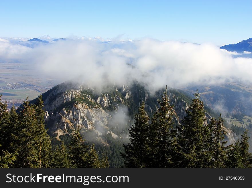 This image presents a spectacular view from the top of a peak in Piatra Craiului mountains in Romania. This image presents a spectacular view from the top of a peak in Piatra Craiului mountains in Romania.