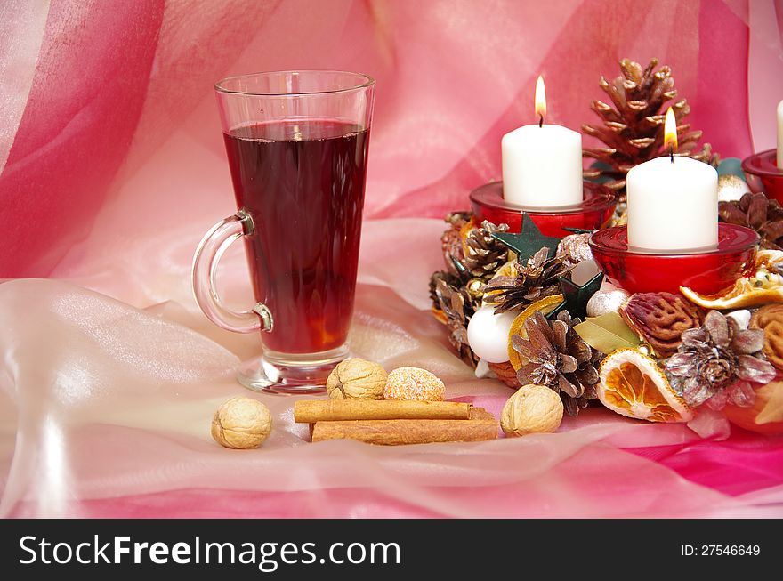 Christmas wreath with burning candles, a hot drink on a light pink background. Christmas wreath with burning candles, a hot drink on a light pink background