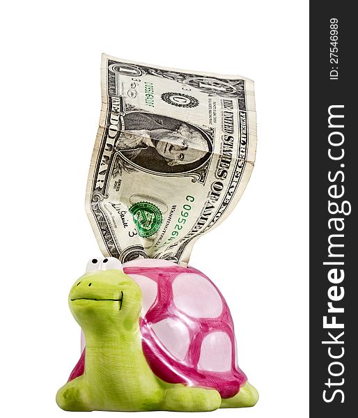 One crumpled dollar goes out of a piggy bank in the form of a funny turtle isolated on white. One crumpled dollar goes out of a piggy bank in the form of a funny turtle isolated on white.