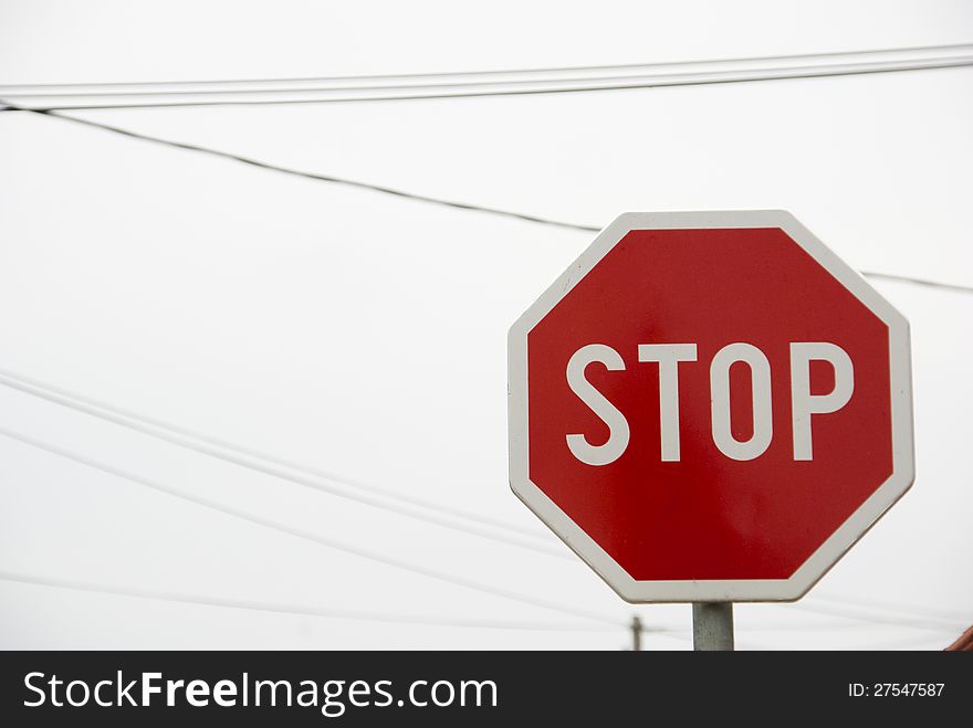 Stop traffic sign with sky and some cables in the background. Stop traffic sign with sky and some cables in the background.