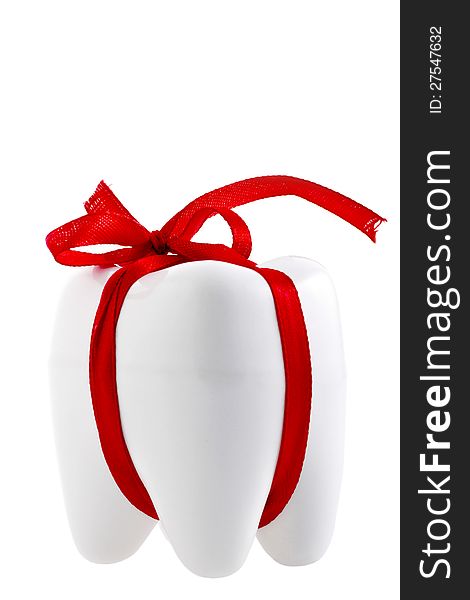 Artificial festive human tooth shape with a festive red ribbon isolated on white