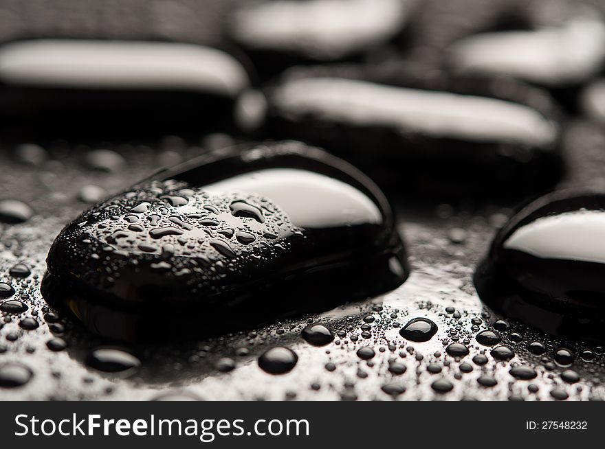 Spa background. Black stones with water drops