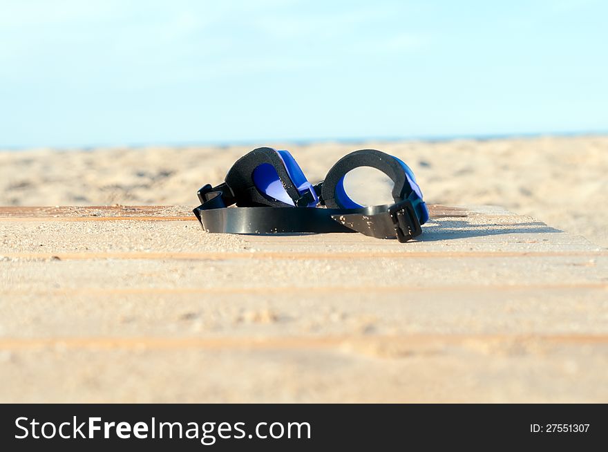 Closeup underwater glasses on the sandy seascape