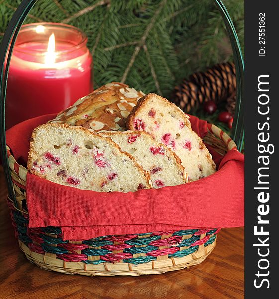 Basket of cranberry sweet bread with a burning candle in background. Basket of cranberry sweet bread with a burning candle in background