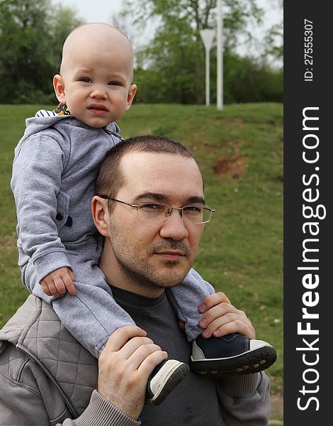 Father and son on a walk in the park.baby sitting on the shoulders of a man