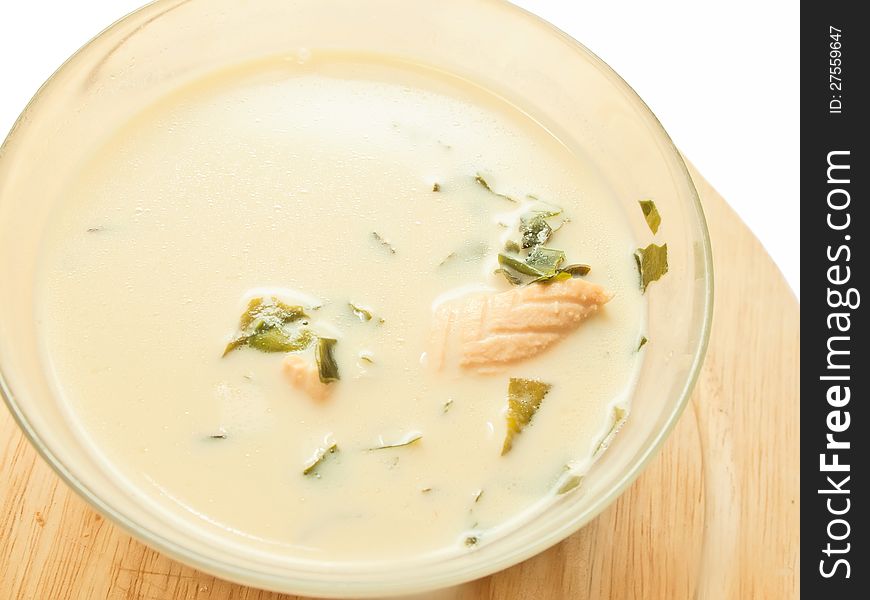 Cream soup with salmon and weed over white. studio