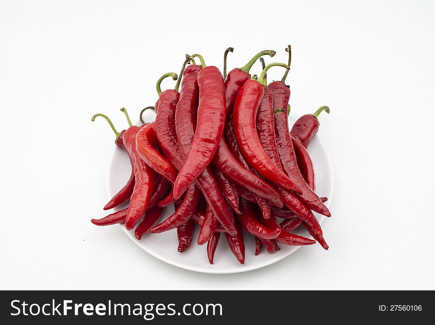 Lot of red chili peppers on a white plate. Lot of red chili peppers on a white plate