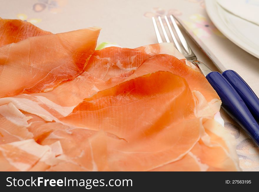 Cured ham slices over dressed table