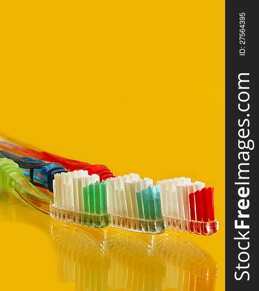 Colorful tooth brush set on yellow counter top. Colorful tooth brush set on yellow counter top