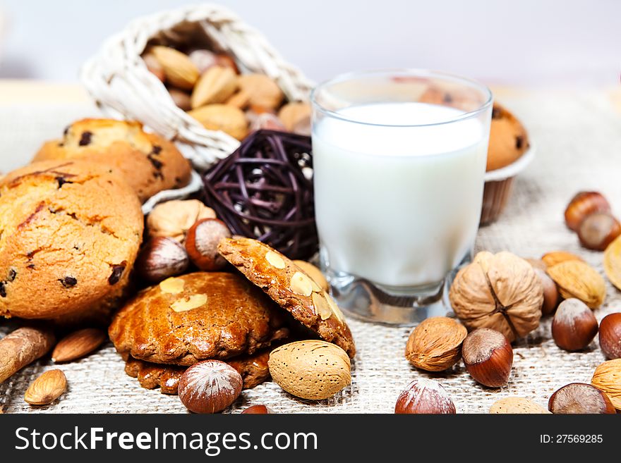 Cookies, nuts, muffins and glass with milk