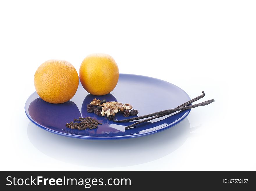 Picture of vanilla sticks and oranges on a blue plate, on an isolated white background