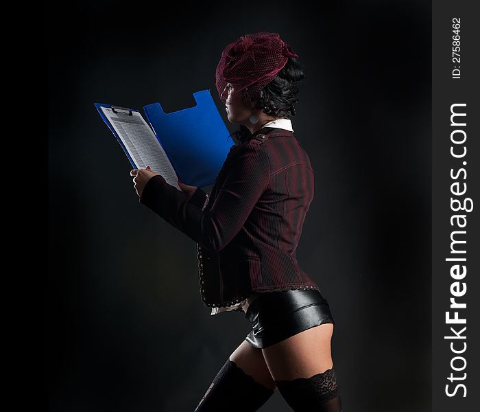 Portrait of woman in erotic clothes showing perfect body on a dark background in the studio. Portrait of woman in erotic clothes showing perfect body on a dark background in the studio