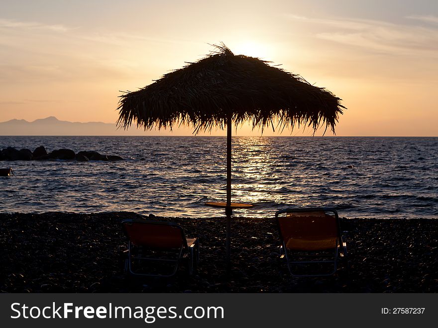 One pair of sunchairs at sunset, Greece, Santorini island