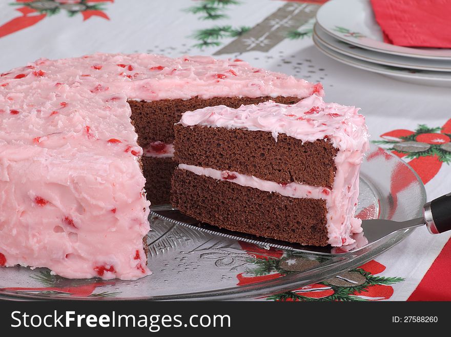 Serving a slice of chocolate layer cake with cherry frosting. Serving a slice of chocolate layer cake with cherry frosting