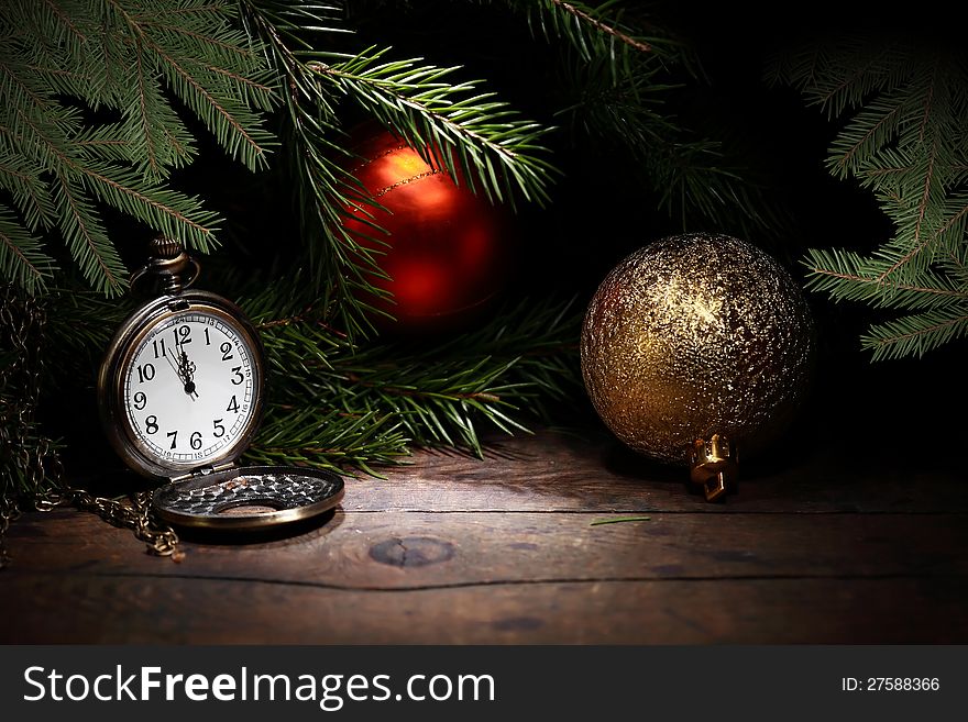 Christmas decoration. Vintage pocket watch on old wooden surface near fir twigs. Christmas decoration. Vintage pocket watch on old wooden surface near fir twigs
